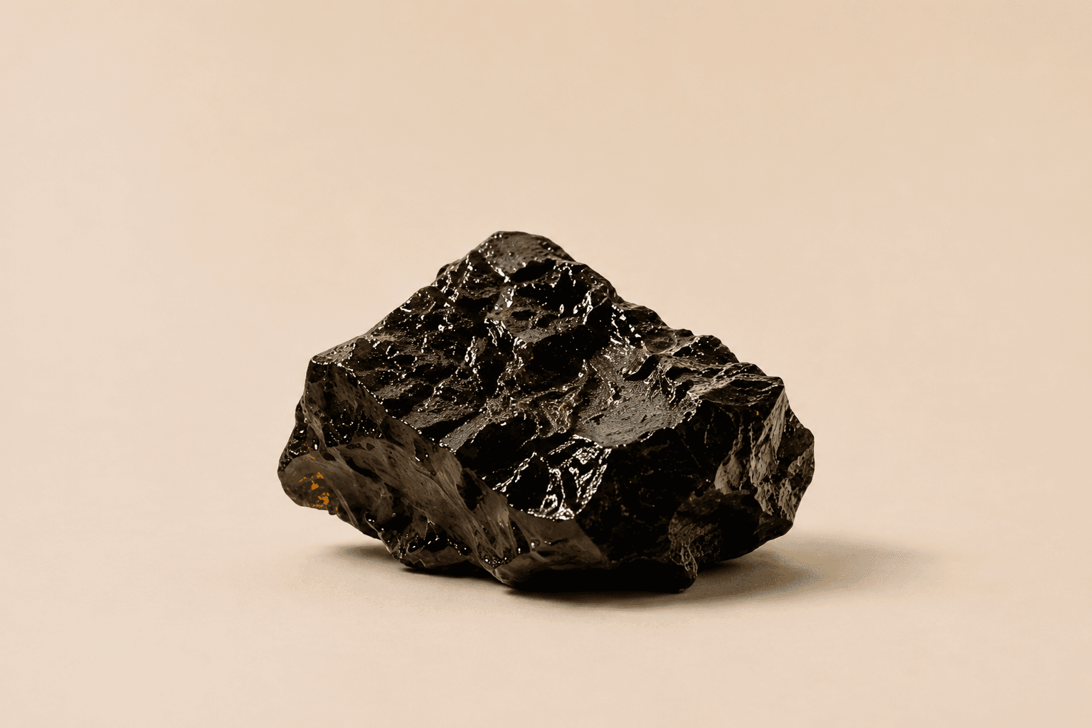 A dark, glossy piece of raw shilajit resin